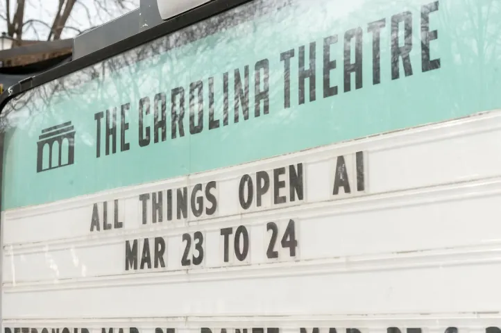 The Carolina Theatre marquee in Durham reading ALL THINGS OPEN AI, MAR 23 TO 24. Ronald Reagan once played this stage; All Things AI was held here in 2025 and 2026