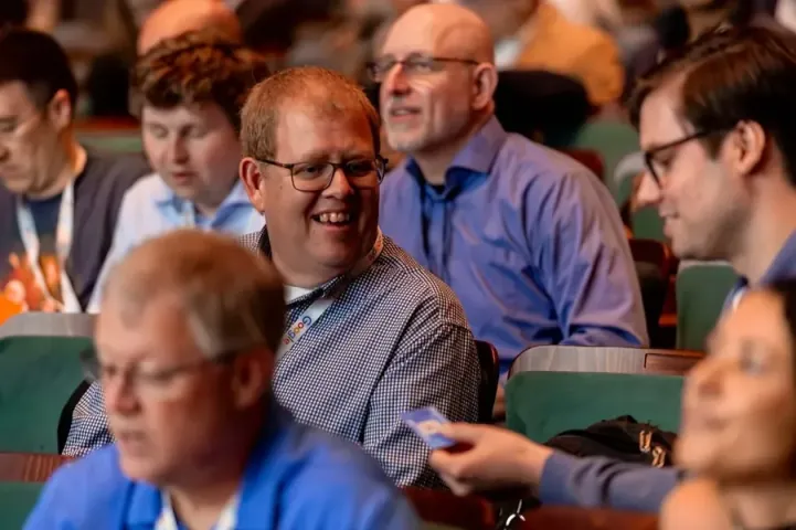 Attendees in the Carolina Theatre laughing together during a session on AI for business professionals