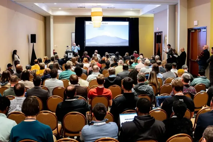 A packed breakout room in a deep dive on AI models, a mountain on the slide behind the speaker
