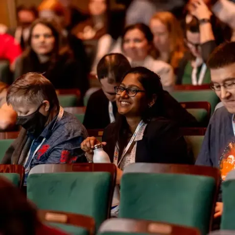 Attendees in the Carolina Theatre's green seats smiling at something said on stage