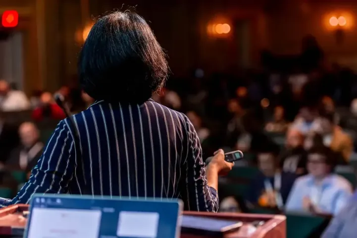 Pam Didner, seen from behind at the podium, walking a full Carolina Theatre through how to use Microsoft Copilot
