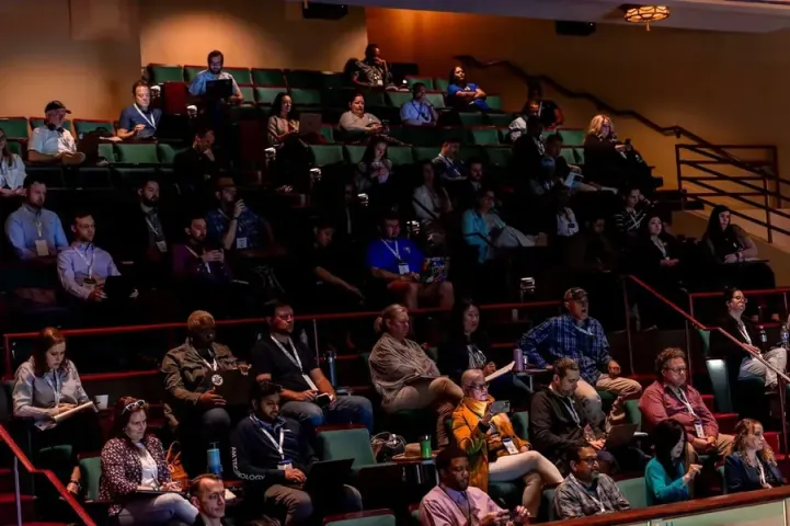 Attendees across three levels of the Carolina Theatre's raked seating for a 2026 training session, laptops and notebooks open