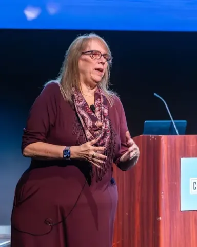Victoria Vojnovich, PhD, Global Principal for AI-led Transformation at HCLTech, speaking on the Carolina Theatre stage