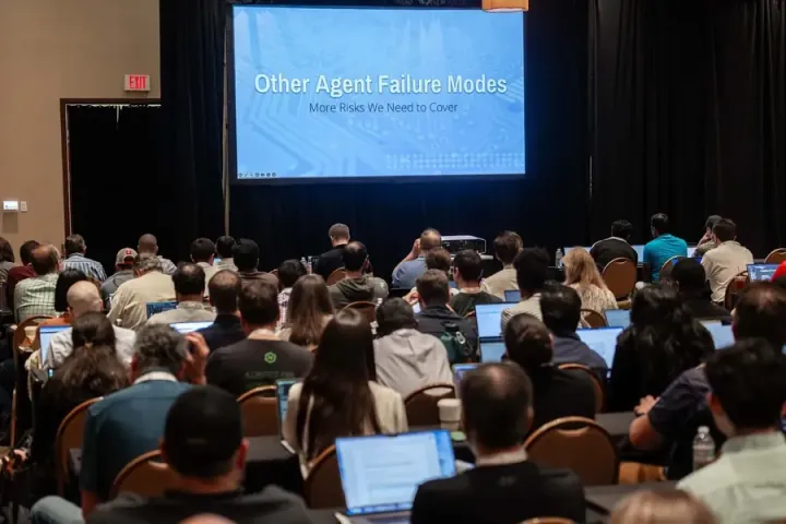 A full agentic AI session, laptops open beneath a slide on agent failure modes