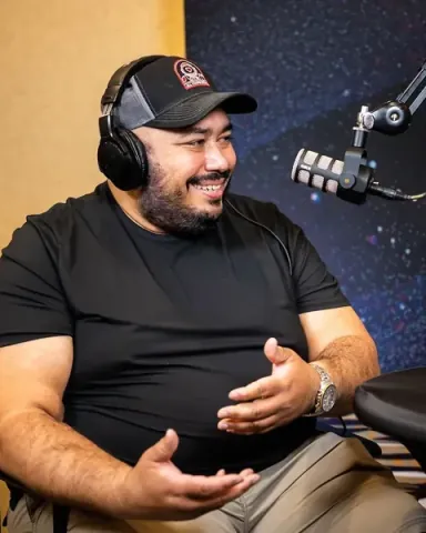 Danny Castro in headphones at the podcast booth, talking about his new RTP chapter of AI Tinkerers