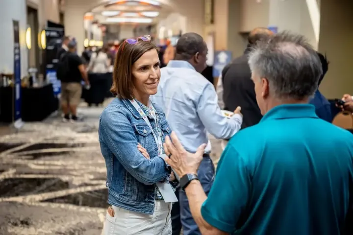 Keith Boswell of Scaled Agile, in a teal shirt, giving his pitch to an attendee in the expo hall