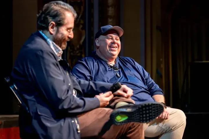 Igor Jablokov, who founded Yap, Amazon's first AI acquisition, in a fireside chat on the Carolina Theatre stage with Mark Hinkle, who is laughing beside him
