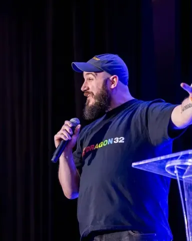 Darko Mesaros, Principal Developer Advocate at AWS, throwing one arm wide on the keynote stage