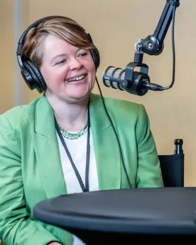 Jennifer McFarland, Founder and CEO of Marit Digital, laughing into the microphone at the podcast booth