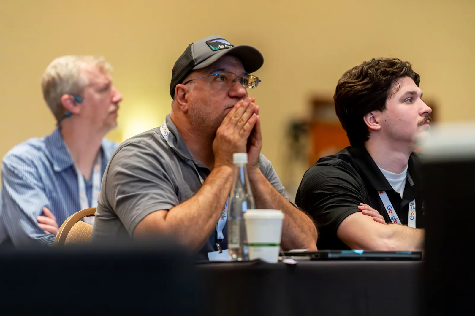 Three attendees watching a workshop presentation at All Things AI 2026