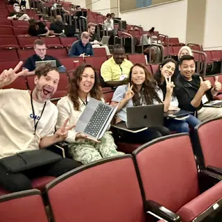 A group at Build an Agent Day in Charlotte smiling over their laptops
