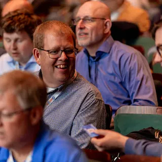 People in theater seats laughing during a session