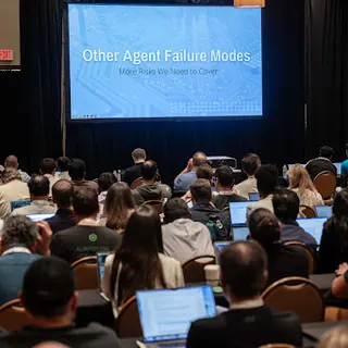 A packed session with laptops open across the audience