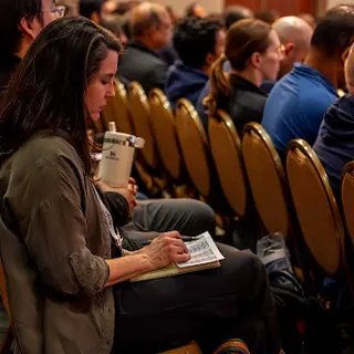 A person taking notes by hand in a session